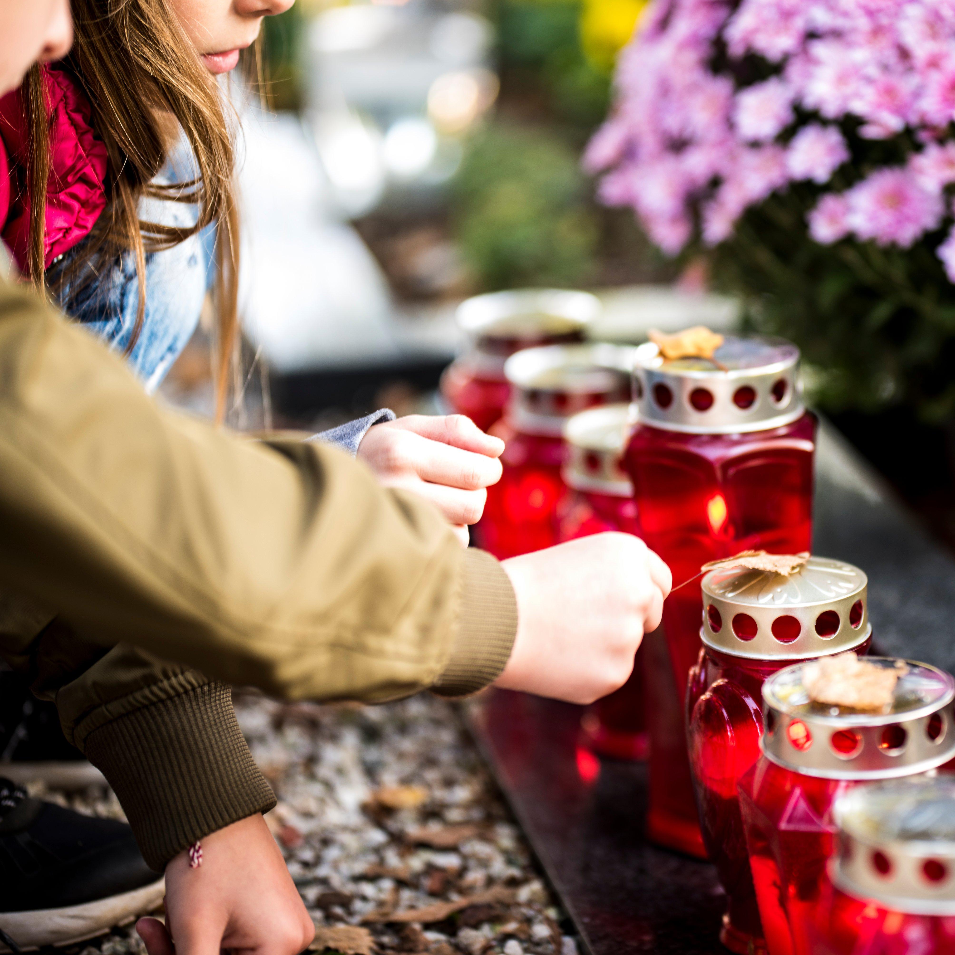 people-lighting-memorial-candles